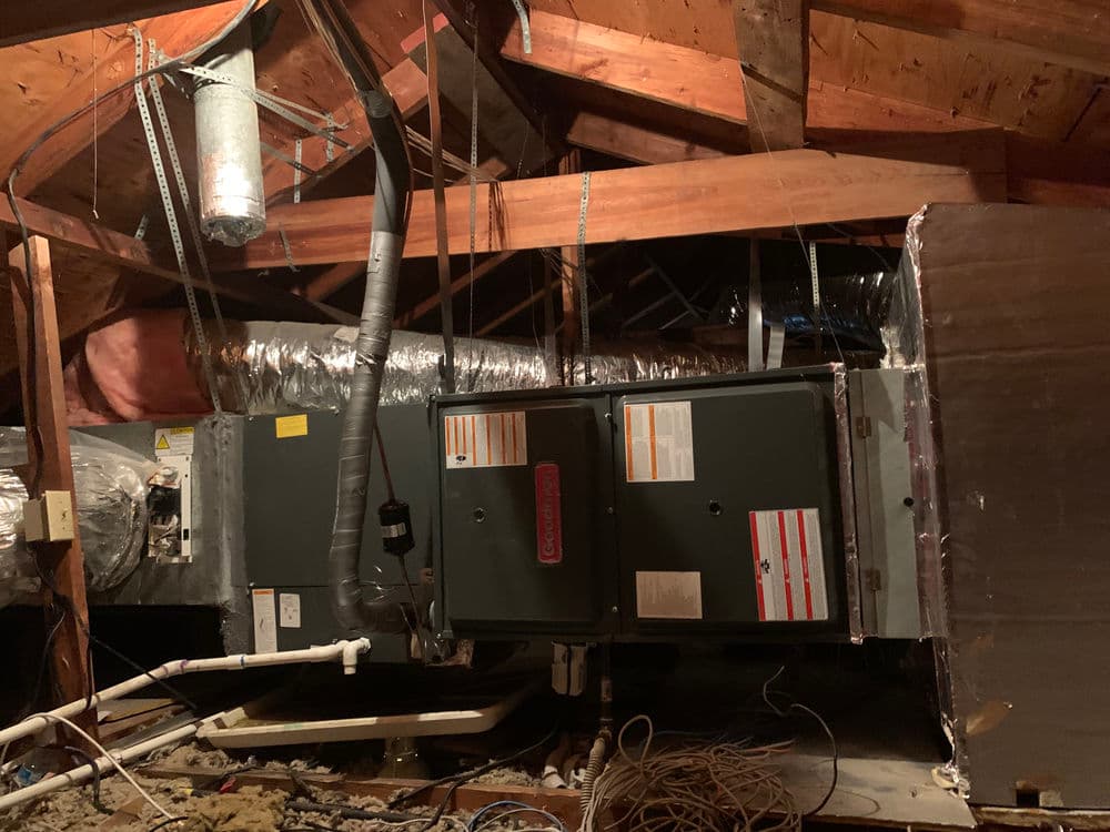HVAC system installed in an attic, showing ductwork and ventilation details.